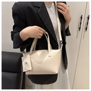Close-up of beige tote bag with mini coin purse shown on a model for casual office wear
