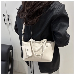 White bucket bag with mini pouch shown from behind on a model wearing a black blazer