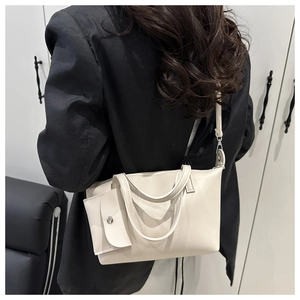 Detailed shot of a creamy white leather bucket bag with an envelope coin purse and strap