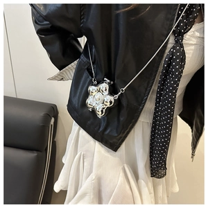 Nahaufnahme einer silbernen Blumentasche mit Perle und feiner Metallkette für Damen