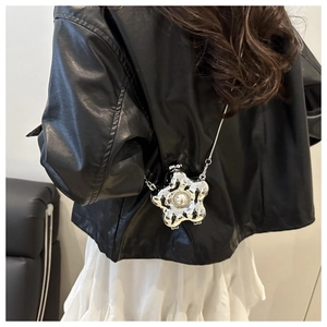 Chic silver star crossbody bag with pearl detail worn over a black leather jacket