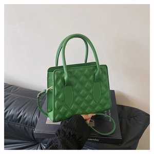 Detail of grass green crossbody bag with rhombus pattern and detachable shoulder strap
