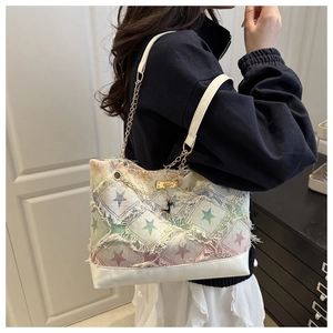 Detail of star pattern fabric tote with chain strap and small deer metal charm