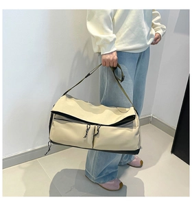 Detailed view of large travel bag with olive green straps and front zipper pockets