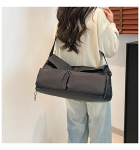 Model view of a black nylon crossbody bag with large capacity and double front pockets