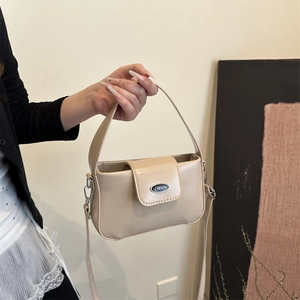 Minimalist beige leather shoulder bag with top handle and silver buckle detail