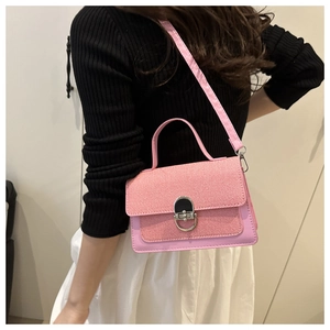Detail of pink crossbody bag with woven texture flap and silver metal ring lock