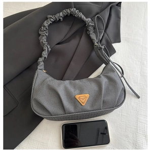Detail of grey herringbone fabric underarm bag with scrunchie strap and triangular logo