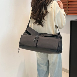 Black nylon multifunctional travel bag with shoulder strap shown on model for daily commuting