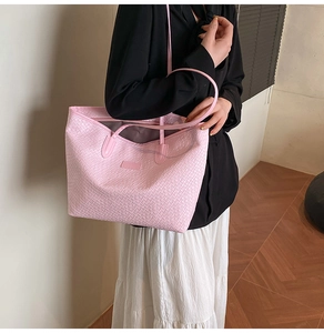 Detail shot of the pink woven texture and slim shoulder straps on this large tote bag