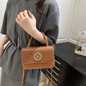 Sac à main rétro marron caramel avec texture tressée et logo M doré en scène