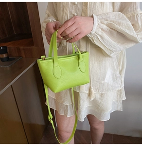 Detail of lime green pebble leather tote bag with gold hardware and shoulder strap