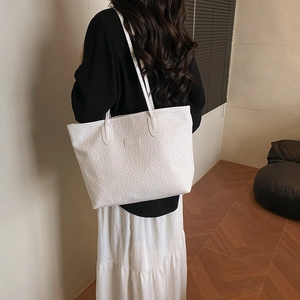 White woven faux leather tote bag with large capacity shown on model in a warm room