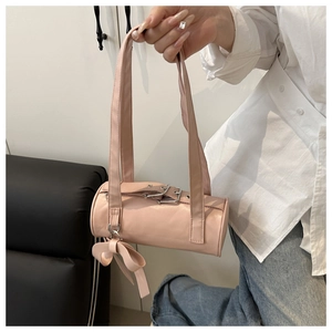 Pink cylinder baguette bag featuring a silver buckle detail and cute bow charm