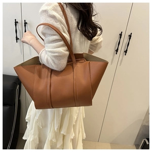 Detailed view of caramel leather tote bag showing fine stitching and fashion embossing
