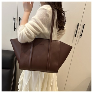 Detailed view of dark brown tote bag with FASHION embossment on premium PU leather