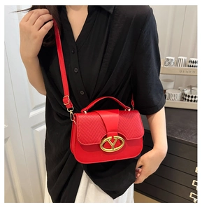 Detalle de bolso de silla rojo con textura tejida y hebilla metálica dorada en V