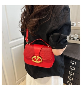 Detalle del bolso silla rojo con textura tejida, hebilla dorada y correa de cuero
