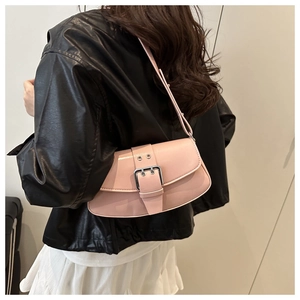Detail view of pink leather underarm bag with silver square buckle on a model