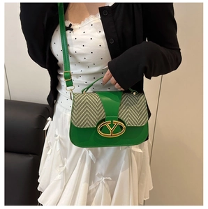 Detalle del bolso de montura verde con cuero brillante y hebilla de metal dorado