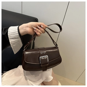 Close-up of vintage dark brown saddle bag with silver buckle and glossy texture leather