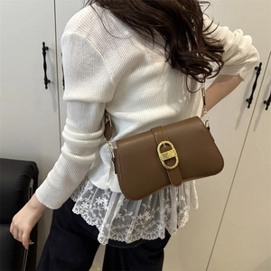 Brown vintage PU leather shoulder bag with a gold oval buckle shown on a model