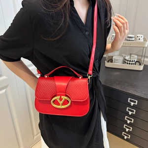 Elegante bolso de silla rojo con textura tejida y herrajes dorados en una modelo