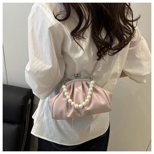 Detailed view of pink pleated shell handbag with large pearl handle and silver chain