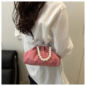 Detail of pink pleated cloud bag with pearl handle and silver chain on model back