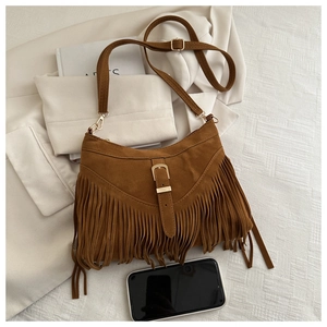 Detail of vintage brown suede tote bag with dynamic fringe and gold buckle closure