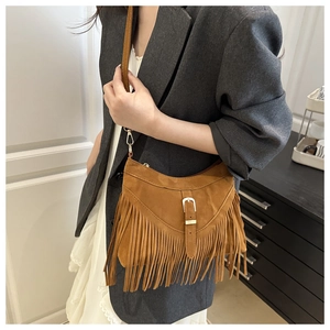 Close-up of brown suede hobo bag featuring bohemian tassels and gold buckle detail
