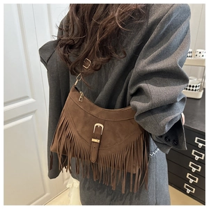 Detailed view of vintage brown suede tote bag with long fringe tassels and golden buckle