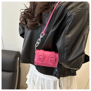 Detail of rose pink mini crossbody bag with woven texture and acrylic chain on model