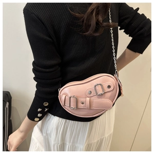 Detail of pink heart-shaped PU leather crossbody bag with silver chain and metal buckle