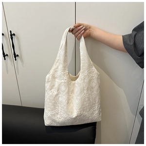Close-up of elegant white floral lace embroidery on a lightweight tote bag