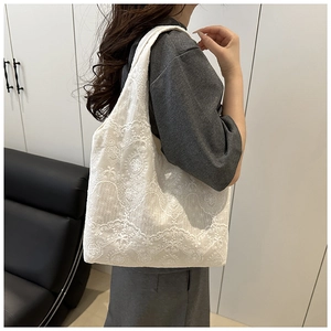 Detail of white lace embroidery texture on a minimalist French style tote shoulder bag