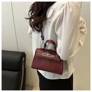 Detail of vintage dark red crossbody bag with silver lock and adjustable strap