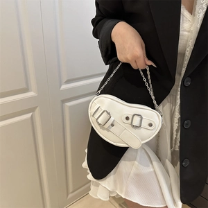 Chic heart-shaped white leather saddle bag with silver chain strap shown by a model