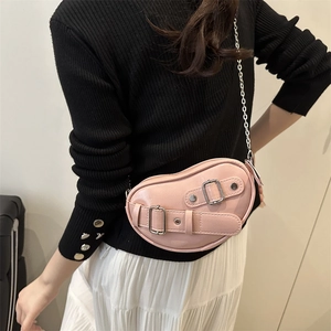Pink bean-shaped crossbody bag with silver buckle straps and chain, shown on shoulder model