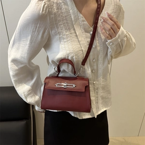 Classic burgundy top handle bag with silver lock and adjustable shoulder strap for women