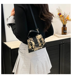 Detail of snake skin texture and gold rivets on a mini stylish shoulder bag for women