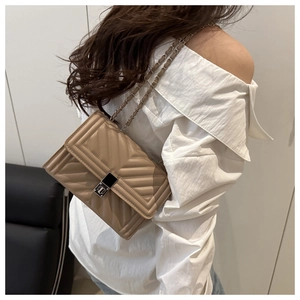 Detailed view of chevron quilted shoulder bag with silver clasp and chain strap