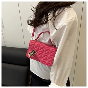 Vista dettagliata della borsa trapuntata magenta con chiusura dorata e catena su modella