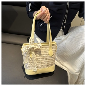 Detailed macro view of straw woven texture with yellow leather trim and a lace bow