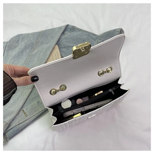 Interior detail of white quilted chain bag showing main compartment and zipper pocket