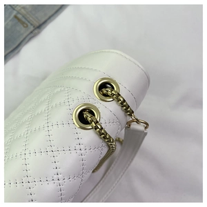 Close-up of white quilted leather bag showing gold eyelets and premium chain strap detail