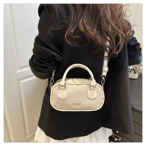 Detailed view of the beige pillow handbag showing the grainy texture and brand lettering