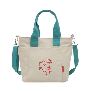 Minimalist canvas crossbody bag with cartoon bear print and green handles in white background