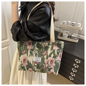 Detailed close-up of a floral tapestry tote bag with red hibiscus and cotton straps