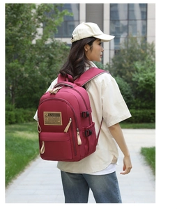 Foto all'aperto di un grande zaino in nylon bordeaux con logo SLFASHION e fibbie